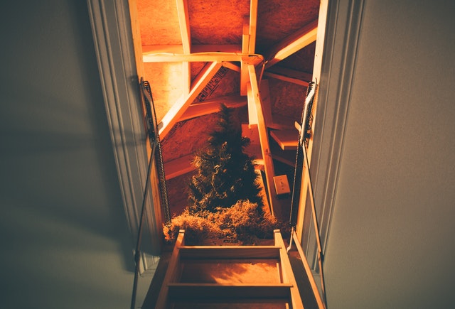 ladder going up to attic with christmas tree in storage